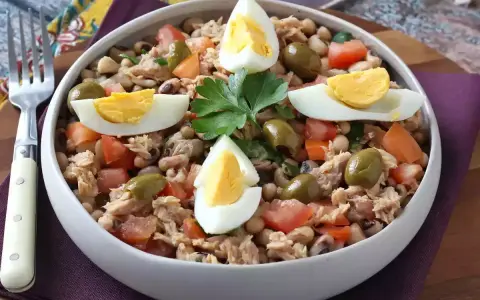 Salade de thon, haricots, tomates et olives, garnie d'œufs durs. Une idée repas facile et rapide.