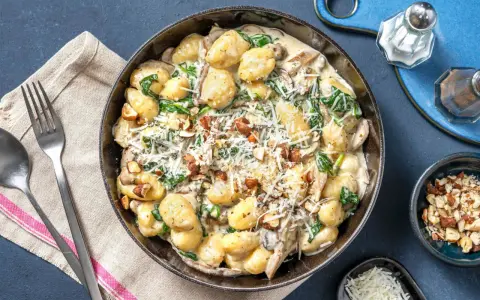 Gnocchi crémeux aux champignons, épinards et noix, saupoudrés de parmesan. Un délice réconfortant.