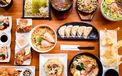 Un festin de nourriture japonaise nom : ramen, tempura, gyoza, riz frit et plus encore, prêt à être dégusté.
