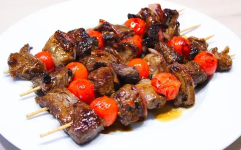 Brochettes de bœuf juteuses et grillées, alternant avec des tomates cerises éclatantes. La meilleure marinade brochette boeuf pour un goût inoubliable.