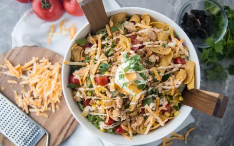 Salade Tex Mex généreuse avec poulet émietté, maïs, tomates cerises, fromage râpé, éclats de tortilla et une touche de crème. Parfait pour un repas plein de saveurs.