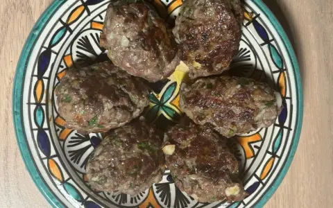 Cinq boulettes de kefta, prêtes à être dégustées, sur une assiette décorée. Une recette simple et savoureuse.