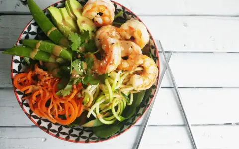 Un poke bowl crevette facile et coloré avec avocat, carottes spirales, courgettes en nouilles et pois gourmands.