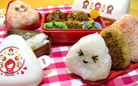Un joyeux repas avec des onigiri crevette et d'autres délices dans des boîtes bento colorées.