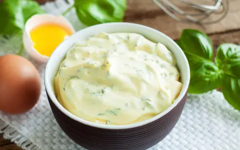 Mayonnaise onctueuse au basilic, avec un œuf et des feuilles de basilic frais.