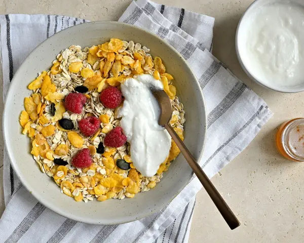 Un bol de céréales, flocons d'avoine, framboises et fromage blanc. Une recette saine et gourmande pour le petit-déjeuner.