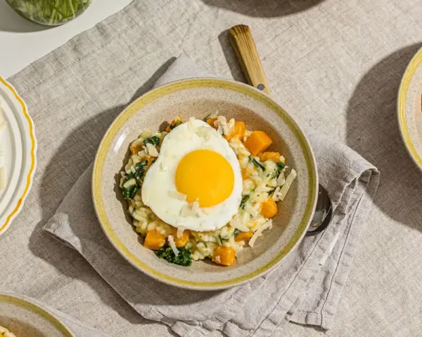 Risotto crémeux aux courges et épinards, garni d'un œuf au plat. Une recette avec des œufs qui promet un repas réconfortant.
