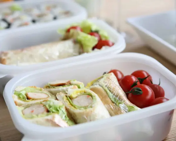 Sandwichs et tomates cerises dans une boîte, une idée de recette lunch box facile et rapide pour un repas sain.
