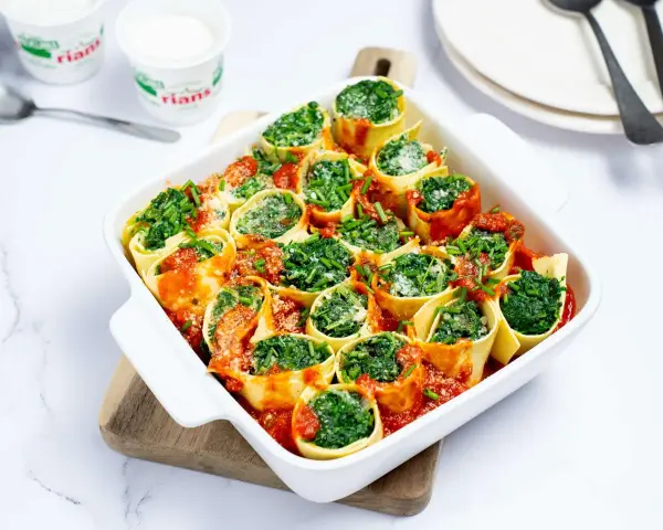 Cannellonis farcis aux épinards et ricotta, nappés de sauce tomate. Une délicieuse recette pas cher, parfaite pour un repas convivial.