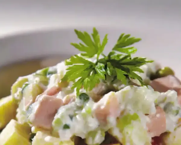 Une délicieuse salade piémontaise crémeuse, garnie de persil frais.
