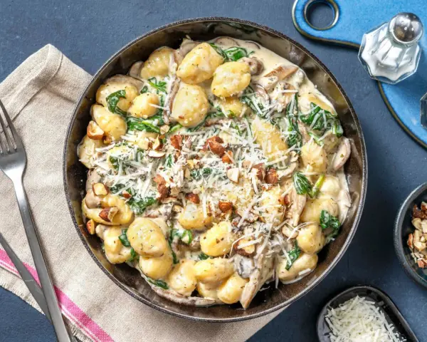 Gnocchi crémeux aux champignons, épinards et noix, saupoudrés de parmesan. Un délice réconfortant.