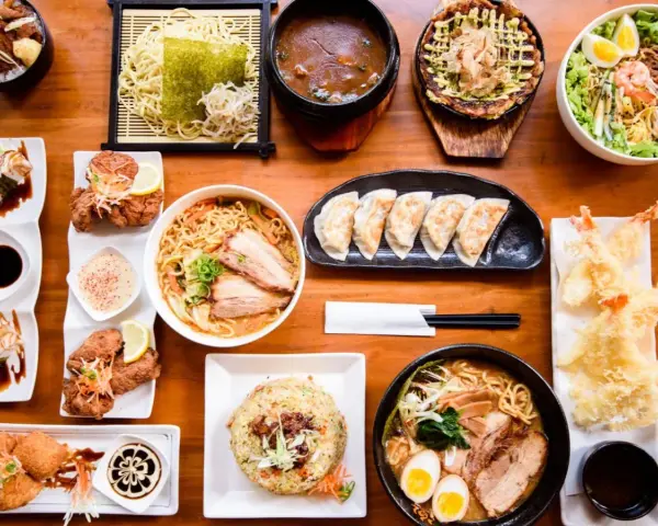 Un festin de nourriture japonaise nom : ramen, tempura, gyoza, riz frit et plus encore, prêt à être dégusté.