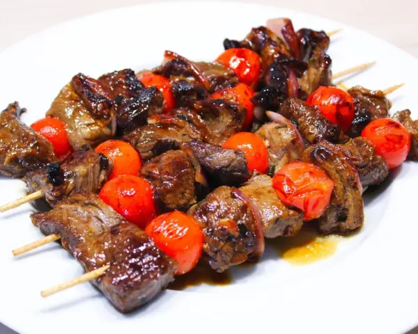 Brochettes de bœuf juteuses et grillées, alternant avec des tomates cerises éclatantes. La meilleure marinade brochette boeuf pour un goût inoubliable.