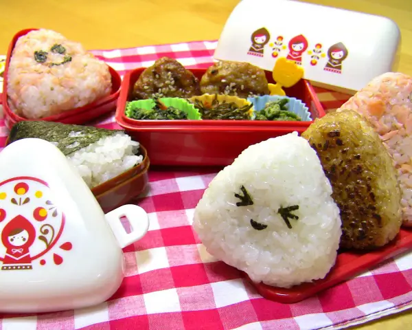 Un joyeux repas avec des onigiri crevette et d'autres délices dans des boîtes bento colorées.