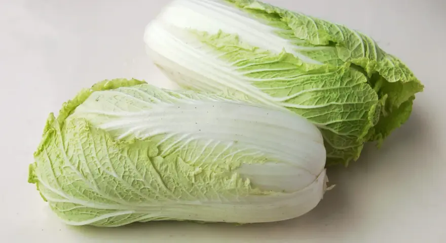 Deux choux chinois frais, aux feuilles vertes et blanches, prêts à être cuisinés.