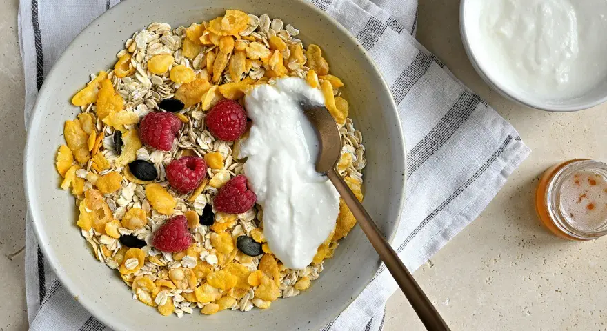 Un bol de céréales, flocons d'avoine, framboises et fromage blanc. Une recette saine et gourmande pour le petit-déjeuner.