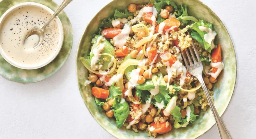 Salade colorée de quinoa, pois chiches, carottes et laitue, arrosée d'une sauce crémeuse. Une recette healthy simple et savoureuse.
