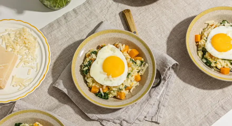 Risotto crémeux aux courges et épinards, garni d'un œuf au plat. Une recette avec des œufs qui promet un repas réconfortant.
