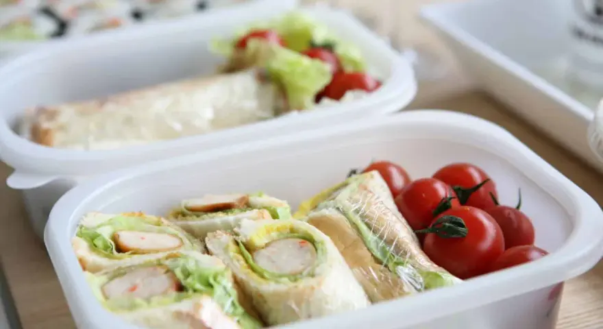 Sandwichs et tomates cerises dans une boîte, une idée de recette lunch box facile et rapide pour un repas sain.