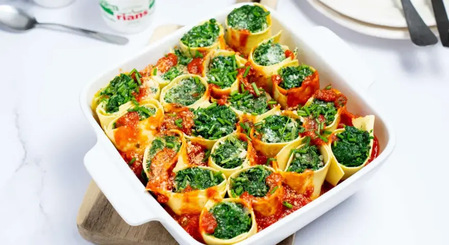 Cannellonis farcis aux épinards et ricotta, nappés de sauce tomate. Une délicieuse recette pas cher, parfaite pour un repas convivial.