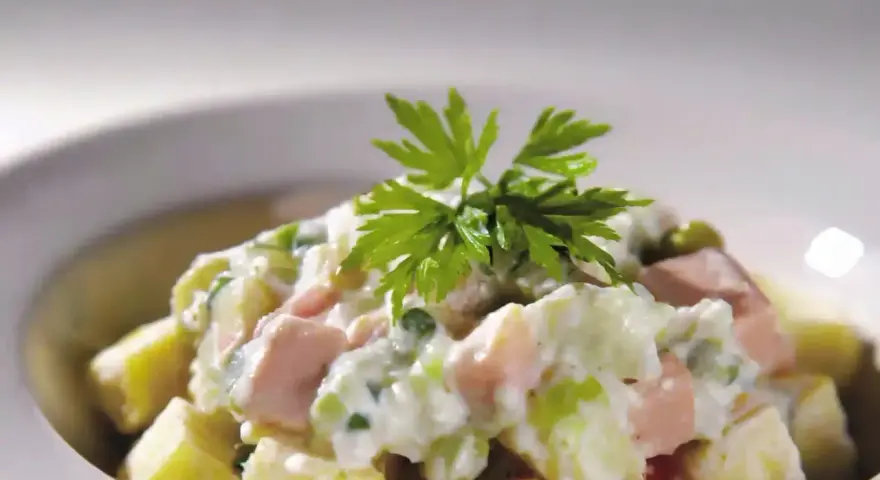 Une délicieuse salade piémontaise crémeuse, garnie de persil frais.