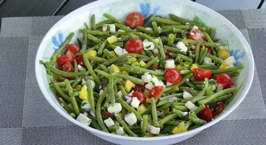Salade colorée de haricots verts, tomates cerises, feta et poivrons jaunes. Un délice frais et croquant pour l'été.