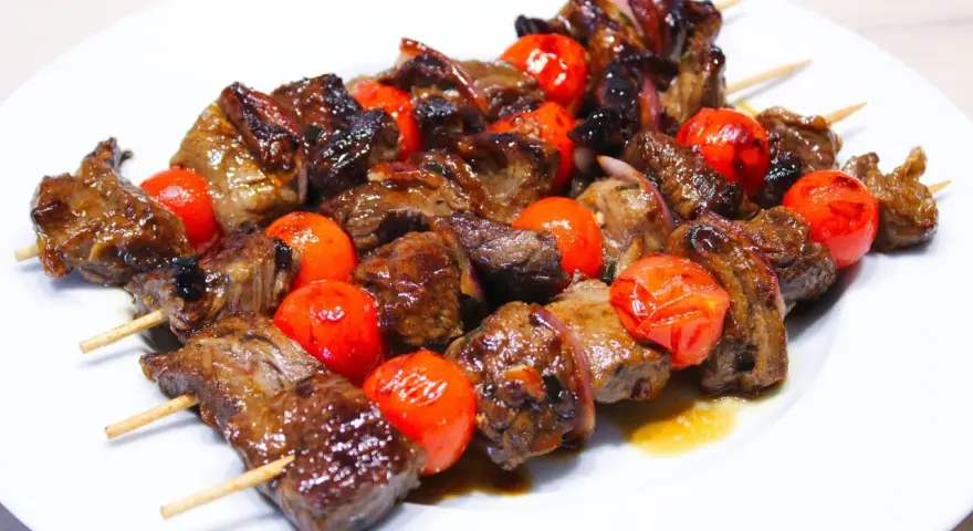 Brochettes de bœuf juteuses et grillées, alternant avec des tomates cerises éclatantes. La meilleure marinade brochette boeuf pour un goût inoubliable.