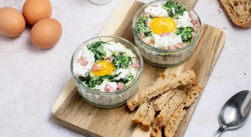 Œufs cocotte aux épinards et dés de jambon, une recette facile pour le midi. Servis avec des mouillettes de pain grillé.