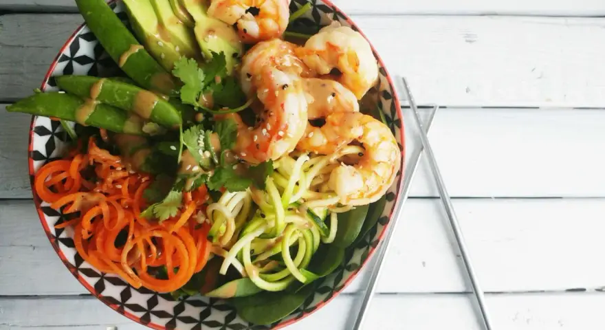 Un poke bowl crevette facile et coloré avec avocat, carottes spirales, courgettes en nouilles et pois gourmands.
