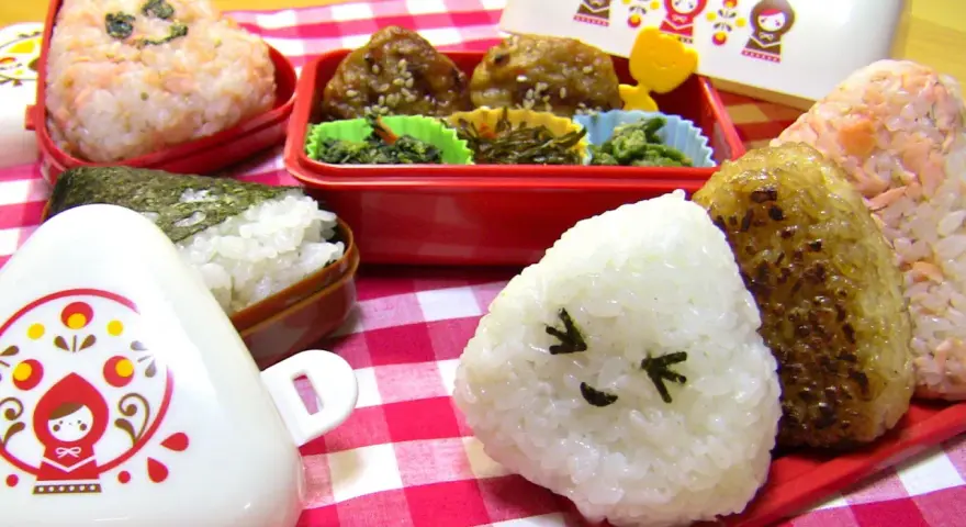 Un joyeux repas avec des onigiri crevette et d'autres délices dans des boîtes bento colorées.