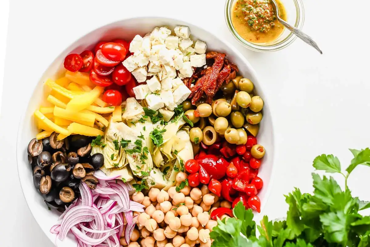 Salade colorée avec cœurs d'artichauts, feta, tomates cerises, olives, poivrons jaunes, oignons rouges et pois chiches. Une vinaigrette est servie à part.