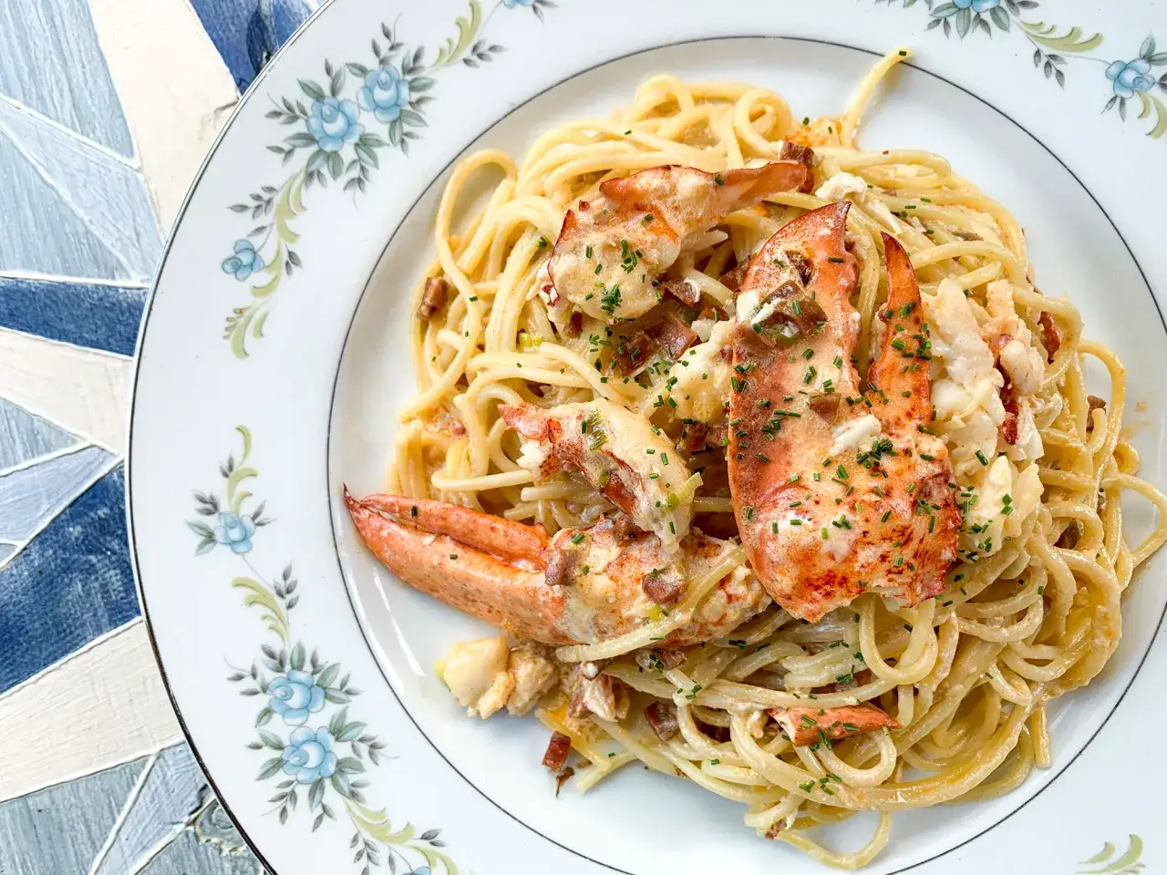Spaghetti cr&eacute;meux avec morceaux de homard et sa sauce homard onctueuse, parsem&eacute; de ciboulette fra&icirc;che.