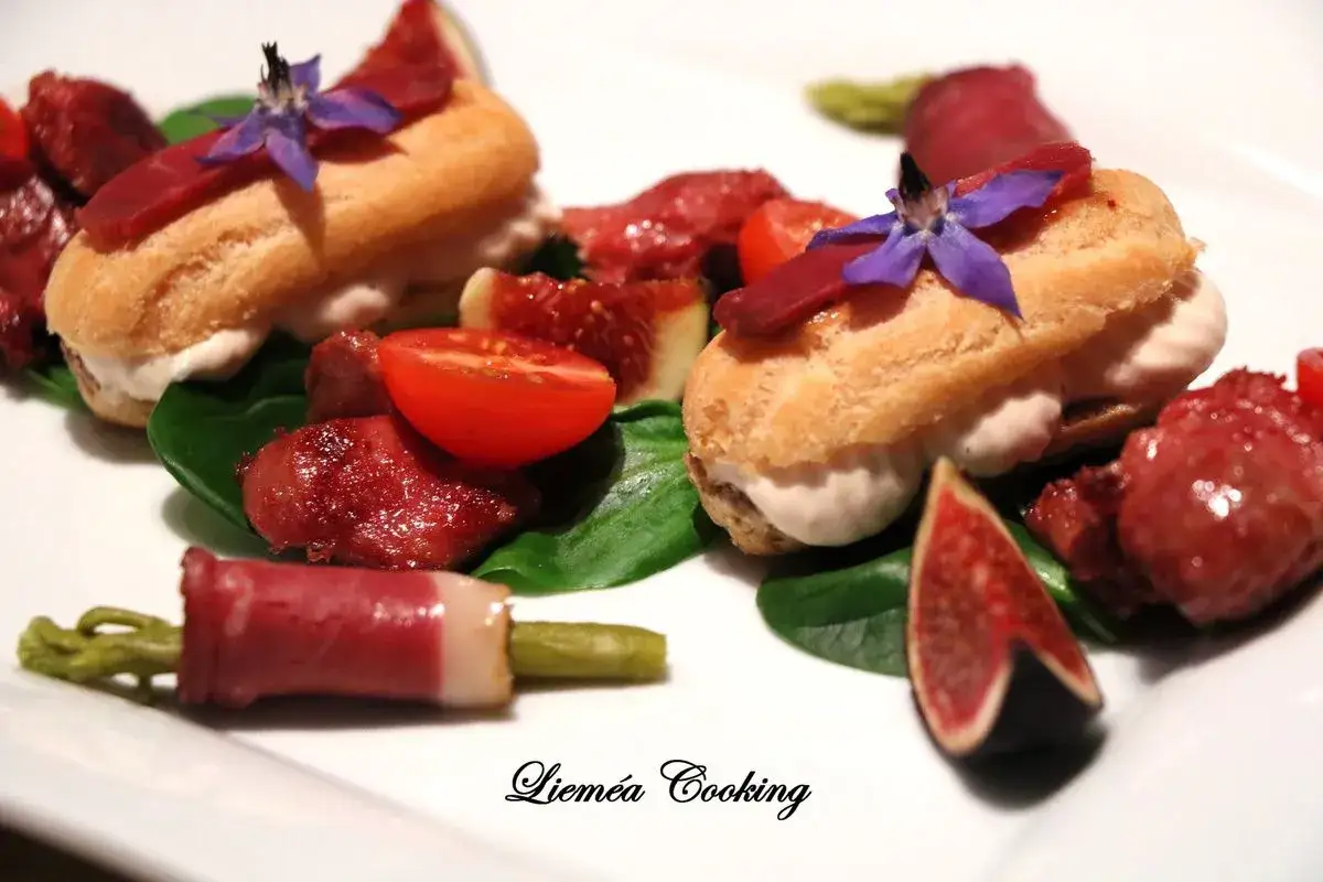 Éclairs garnis de crème, accompagnés de magret de canard, figues, tomates cerises et asperges enroulées de jambon, une délicieuse salade landaise.
