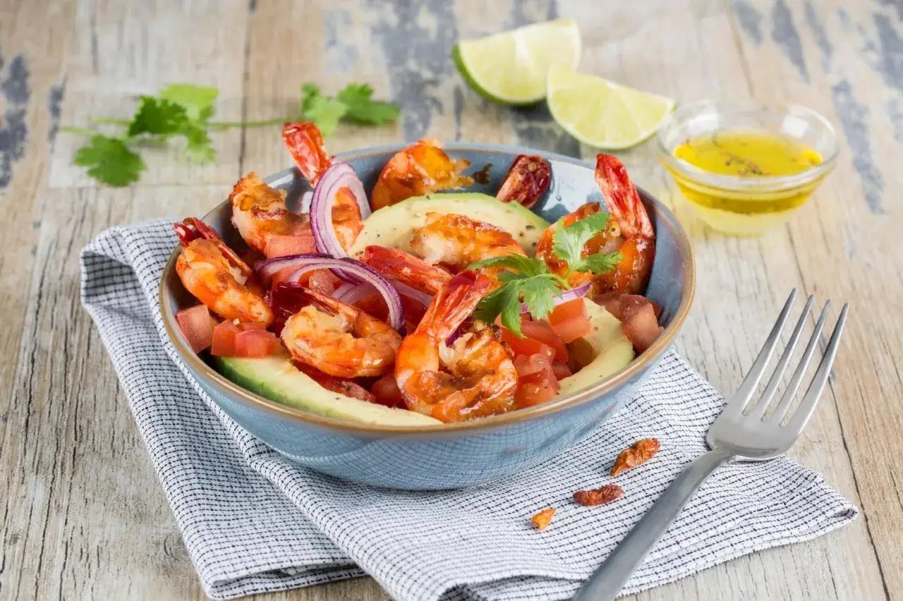 Salade avocat crevette fraîche et colorée, garnie de tomates, oignons rouges et coriandre. Un délice léger et savoureux.