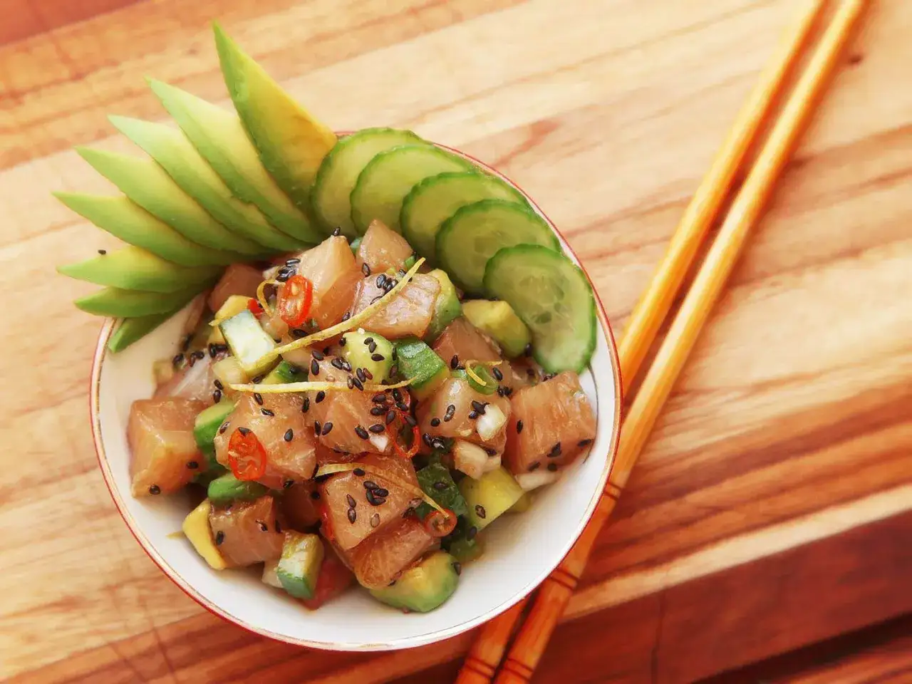 Un d&eacute;licieux base poke bowl avec des d&eacute;s de thon, avocat, concombre et piment, garni de graines de s&eacute;same noir.