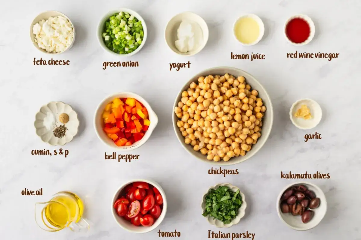 Ingr&eacute;dients pour une salade de pois chiche : pois chiches, feta, poivron, tomates, oignon vert, olives, persil, ail, huile d'olive, yaourt, jus de citron, vinaigre, cumin, sel et poivre.