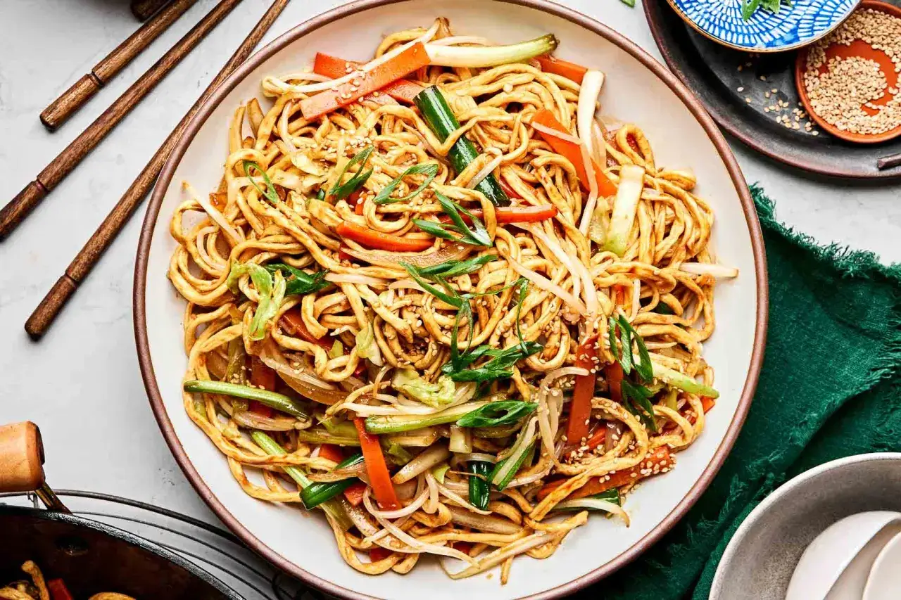 Un plat de chow mein coloré avec des nouilles, des légumes croquants et des graines de sésame.