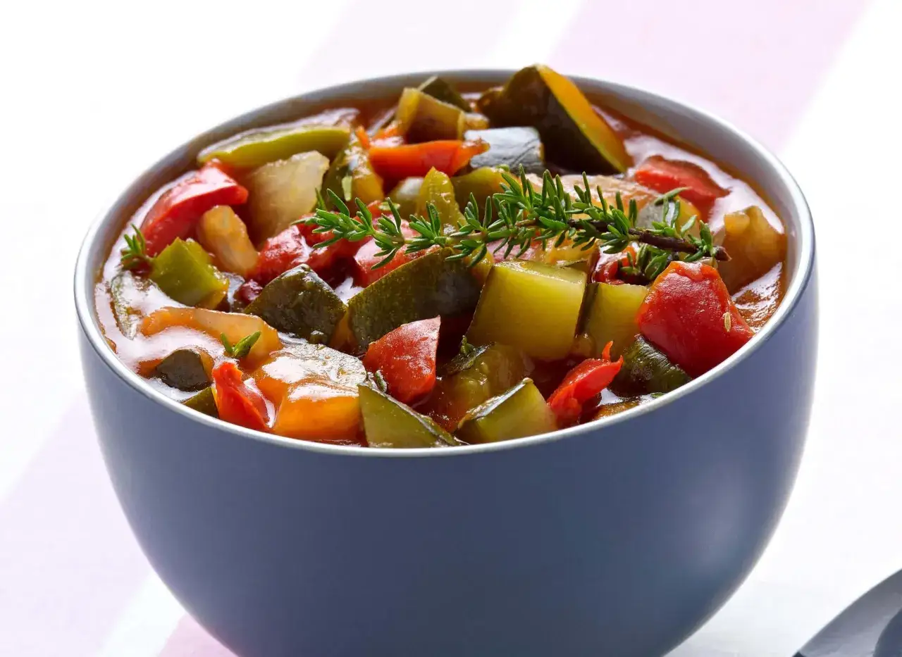 Un bol de ratatouille ni&ccedil;oise, un plat color&eacute; de l&eacute;gumes mijot&eacute;s, garni d'une branche de thym frais.