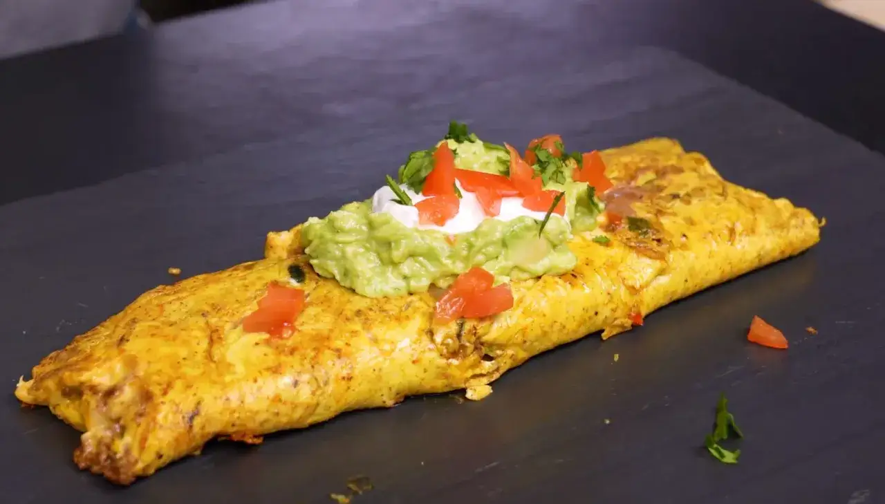 Une omelette mexicaine garnie de guacamole, cr&egrave;me fra&icirc;che et d&eacute;s de tomates, pr&ecirc;te &agrave; &ecirc;tre d&eacute;gust&eacute;e.
