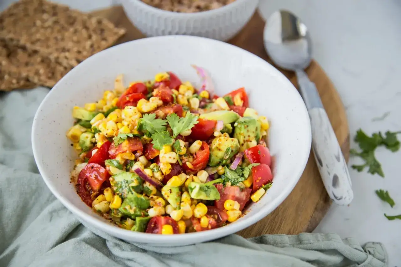 Salade de ma&iuml;s color&eacute;e avec avocat, tomates cerises, oignon rouge et coriandre fra&icirc;che, assaisonn&eacute;e d'&eacute;pices.