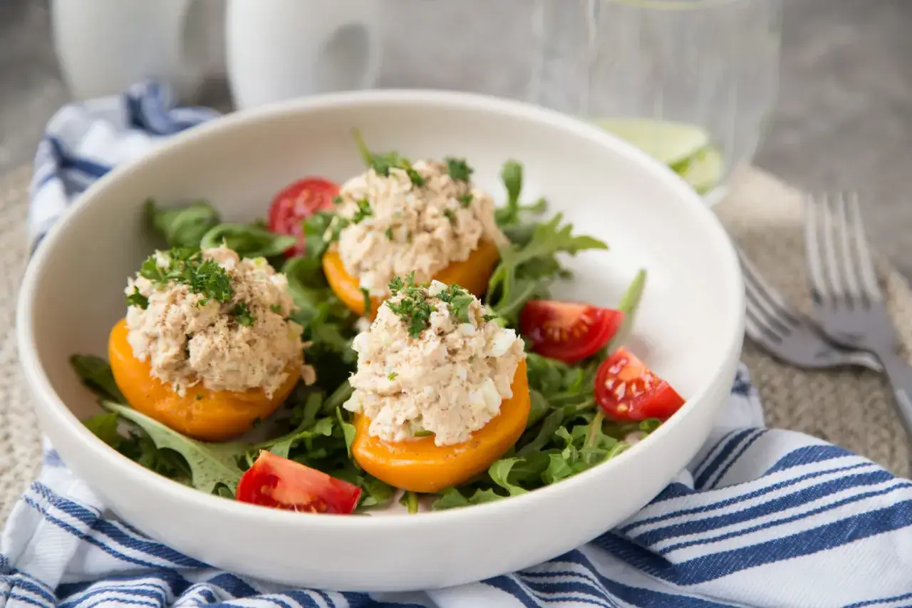 Trois moiti&eacute;s de poivrons jaunes farcies d'une salade de thon cr&eacute;meuse, garnies de persil et servies sur un lit de roquette avec des tomates cerises. Un d&eacute;lice de peche au thon !
