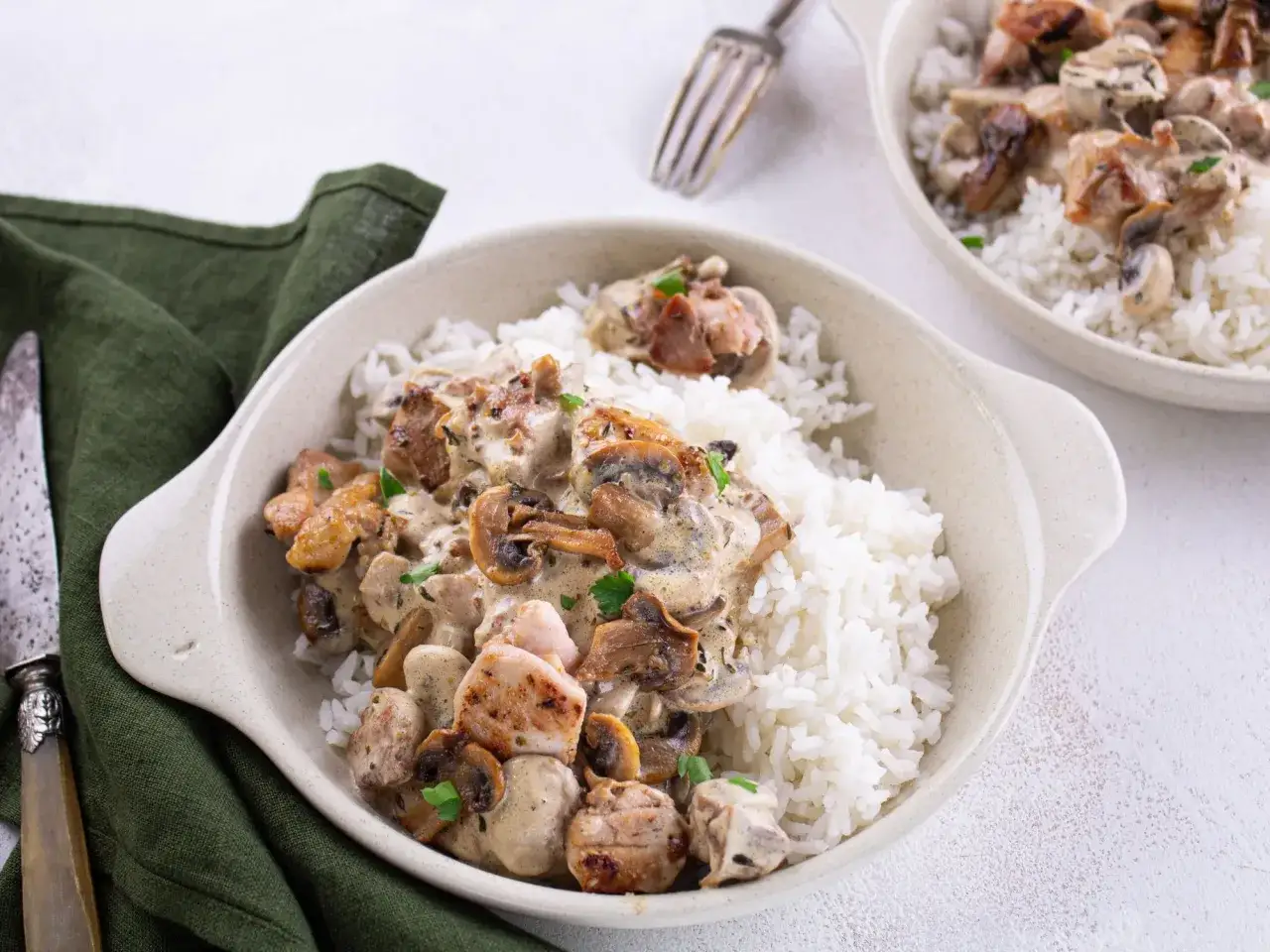 Un plat réconfortant de poulet à la crème et aux champignons, servi sur un lit de riz blanc.