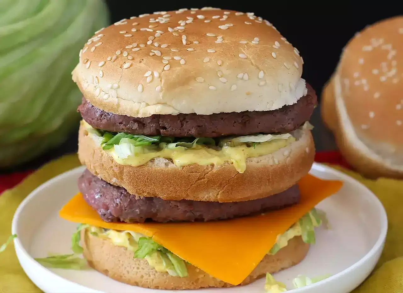 Un burger &agrave; trois &eacute;tages avec deux steaks, de la laitue, du fromage et une g&eacute;n&eacute;reuse sauce Big Mac.