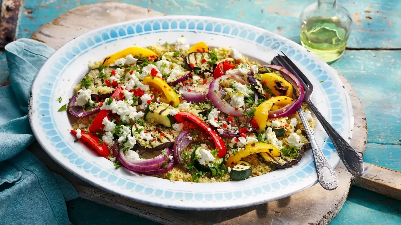 Salade de semoule color&eacute;e avec l&eacute;gumes grill&eacute;s, oignons rouges, poivrons, courgettes, et g&eacute;n&eacute;reusement garnie de feta &eacute;miett&eacute;e et de persil frais. Un d&eacute;lice estival !