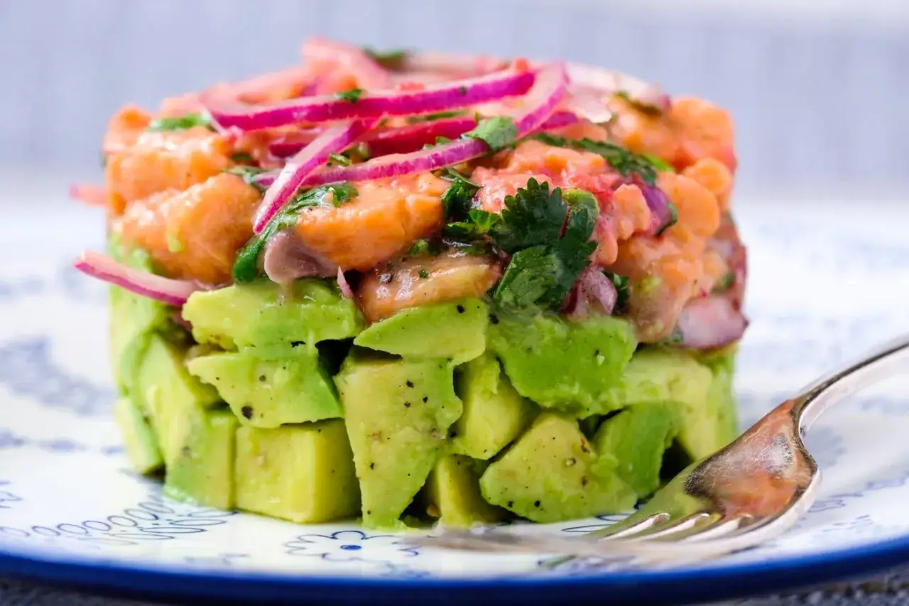Un d&eacute;licieux tartare saumon avocat, frais et color&eacute;, garni d'oignons rouges et de coriandre. Une bouch&eacute;e parfaite pour l'&eacute;t&eacute;.